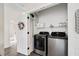 Laundry room with stainless steel washer and dryer, shelving and white door at 121 Longview Ave, Celebration, FL 34747