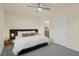 Neutral bedroom featuring gray carpet, a ceiling fan, and a modern bed with lamps at 1219 Lido Dr, Howey In The Hills, FL 34737