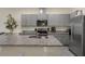 Well-equipped kitchen with gray cabinets, stainless steel appliances, and a granite-topped island at 1219 Lido Dr, Howey In The Hills, FL 34737