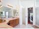 Bright bathroom with wood cabinets, double sinks, and a view leading out to the living area at 12445 Bohannon Blvd, Orlando, FL 32824