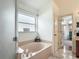 Bright bathroom featuring a soaking tub beside a separate toilet room, providing privacy and comfort at 12445 Bohannon Blvd, Orlando, FL 32824