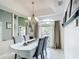 Bright dining room featuring a large window, modern chandelier, and seating for four at 12445 Bohannon Blvd, Orlando, FL 32824