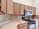 Well-maintained kitchen featuring wood cabinets, neutral countertops, and black appliances at 12445 Bohannon Blvd, Orlando, FL 32824