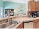 Modern kitchen with wood cabinets, sleek countertops, and a view of the open living space at 12445 Bohannon Blvd, Orlando, FL 32824