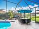 Inviting pool area featuring outdoor dining and barbecue setup in screened enclosure at 12445 Bohannon Blvd, Orlando, FL 32824