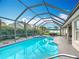 Sparkling pool in screened enclosure with poolside seating and well-manicured landscaping at 12445 Bohannon Blvd, Orlando, FL 32824