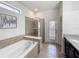 Well-lit bathroom featuring a soaking tub, glass shower, and tiled floor at 1614 Lima Ave, Kissimmee, FL 34747