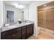 Bathroom with granite countertops, double sinks, tiled floor, and glass shower at 1614 Lima Ave, Kissimmee, FL 34747