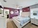 Bedroom featuring a queen-sized bed, ensuite bathroom, and decorative wall mirrors at 1614 Lima Ave, Kissimmee, FL 34747