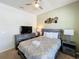 Cozy bedroom featuring a ceiling fan, decorative wall art, and comfortable bedding at 1614 Lima Ave, Kissimmee, FL 34747