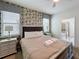 Bedroom with patterned wallpaper, a decorative ceiling fan, and luxury bedding at 1614 Lima Ave, Kissimmee, FL 34747