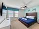 Bedroom featuring a queen-sized bed, large window, ceiling fan, and television at 1614 Lima Ave, Kissimmee, FL 34747