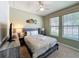 Comfortable bedroom with ceiling fan, two windows, and decorative headboard at 1614 Lima Ave, Kissimmee, FL 34747