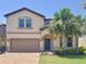 Beautiful two-story home with a red brick driveway, a 2-car garage, and palm trees in the front yard at 1614 Lima Ave, Kissimmee, FL 34747