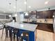 Spacious kitchen with a large island, granite countertops, stainless steel appliances, and dark wood cabinets at 1614 Lima Ave, Kissimmee, FL 34747