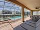 Relaxing covered patio featuring brick flooring, lounge chairs, and a view of the screened-in pool at 1614 Lima Ave, Kissimmee, FL 34747