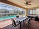 Covered patio with ceiling fan, brick flooring, dining table and a view of the pool at 1614 Lima Ave, Kissimmee, FL 34747