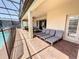 Covered patio with brick flooring, lounge chairs, and access to the backyard and pool area at 1614 Lima Ave, Kissimmee, FL 34747