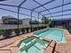 Private screened-in pool and spa with brick surround and lush landscaping at 1614 Lima Ave, Kissimmee, FL 34747