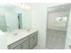 Bright bathroom featuring double vanity sinks, grey cabinets, and tile flooring at 165 Citrine Loop, Kissimmee, FL 34758