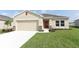 Charming single-story home featuring a neutral color palette, two-car garage, and well-manicured lawn at 165 Citrine Loop, Kissimmee, FL 34758