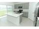 Kitchen with large center island, stainless steel appliances, and grey cabinets at 165 Citrine Loop, Kissimmee, FL 34758