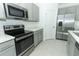 Modern kitchen with stainless steel appliances, grey cabinets, and light countertops at 165 Citrine Loop, Kissimmee, FL 34758