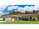 Charming single-story home with a brick facade, well-manicured lawn, and vibrant blue shutters at 1730 Carolyn Ct, St Cloud, FL 34769