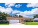 Inviting single-story brick home with an attached garage and a well-maintained front lawn at 1730 Carolyn Ct, St Cloud, FL 34769