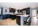 Modern kitchen with dark cabinetry, stainless steel appliances, a center island with seating, and wood flooring at 1730 Carolyn Ct, St Cloud, FL 34769