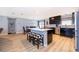 Modern eat-in kitchen with dark cabinetry, stainless steel appliances, an island, and stylish bar stools at 1730 Carolyn Ct, St Cloud, FL 34769