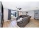 Comfortable living room with wood floors, gray walls, a large sectional sofa, and lots of natural light at 1730 Carolyn Ct, St Cloud, FL 34769