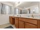 Bathroom with wooden cabinets, a tile floor, and a large mirror at 2060 Patriot Way, St Cloud, FL 34769