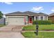 Charming single-story home with a two-car garage and well-maintained landscaping and red front door at 2060 Patriot Way, St Cloud, FL 34769