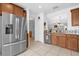 Bright kitchen with stainless steel appliances, tiled floors, wooden cabinetry and granite countertops at 2060 Patriot Way, St Cloud, FL 34769