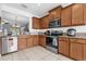 Kitchen featuring stainless steel appliances, light wood cabinets, and a tile backsplash at 2060 Patriot Way, St Cloud, FL 34769