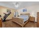 Inviting main bedroom with hardwood floors, a ceiling fan, natural wood furniture, and neutral decor at 2060 Patriot Way, St Cloud, FL 34769
