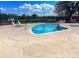 Community pool featuring lounge chairs, playground, and tennis courts at 215 Grovepark Dr, Davenport, FL 33837
