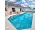 Inviting screened-in pool with clear blue water and patio seating at 215 Grovepark Dr, Davenport, FL 33837