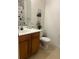 Cozy bathroom features a wooden vanity, toilet, and a shower with patterned curtain at 2203 San Vittorino Cir # 103, Kissimmee, FL 34741