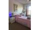 Cozy bedroom featuring a bed with pink linens, a desk, and soft natural light at 2203 San Vittorino Cir # 103, Kissimmee, FL 34741