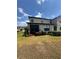 Back exterior of the home featuring a screened patio and well-maintained yard at 2289 Seven Oaks Dr, St Cloud, FL 34772