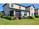 Back of home with screened porch, grill, and manicured hedges overlooking green lawn at 2289 Seven Oaks Dr, St Cloud, FL 34772