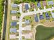Aerial view of a neighborhood showcasing homes with well-maintained lawns and landscaping near a pond at 233 E Cattail, Lake Alfred, FL 33850
