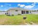 Exterior view of the backyard featuring a fire pit, white fence, and screened-in porch at 233 E Cattail, Lake Alfred, FL 33850