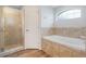 Bathroom featuring tile flooring, a walk-in shower, a bathtub, and a decorative window at 233 E Cattail, Lake Alfred, FL 33850
