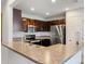 Well-lit kitchen with stainless steel appliances, dark wood cabinets, and stone countertops at 233 E Cattail, Lake Alfred, FL 33850