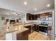 Open kitchen layout featuring stone countertops, stainless steel appliances, and dark wood cabinets at 233 E Cattail, Lake Alfred, FL 33850