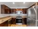 Stylish kitchen featuring stainless steel appliances, wood cabinets, and granite countertops at 233 E Cattail, Lake Alfred, FL 33850