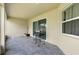 Covered back patio with gray tile flooring and sliding glass doors at 233 E Cattail, Lake Alfred, FL 33850